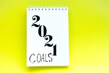 Notebook with white pages on yellow background. Notebook with text 2021. Targets for future year