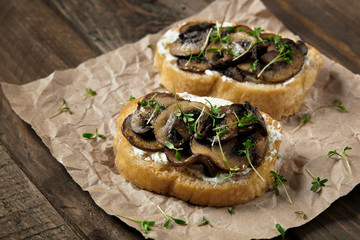 Bruschetta with cheese and mushrooms on parchment.