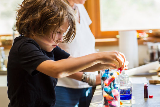 6 Year Old Boy In Kitchen With His Mother, Doing Science Experiment