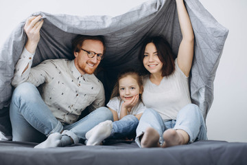 Young parents with children have fun in bed on weekends.