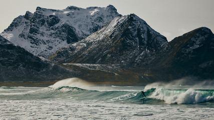 Surfer and snowy mountain backdrop