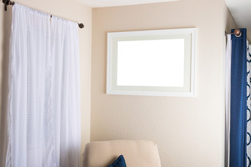 Fototapeta na wymiar A white blank frame picture decorates a fully furnished interior wall.