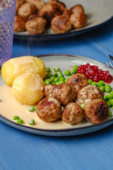 .Swedish meatballs with potatoes on blue wooden table