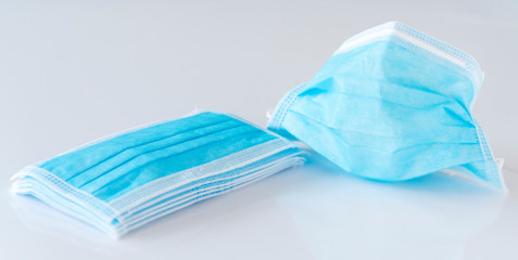 Blue mask and gel bottle blur. Surgical masks and hand sanitizer gel for hand hygiene spread protection.