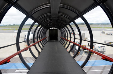 Architektura nowoczesna - rękaw prowadzący do samolotu z teminalu lotniska. - obrazy, fototapety, plakaty