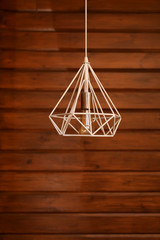 Loft style incandescent white lamp on wood wall background. Modern style home design. selective focus