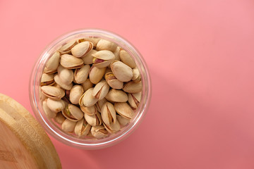 pistachios nut in a jar on pink background .