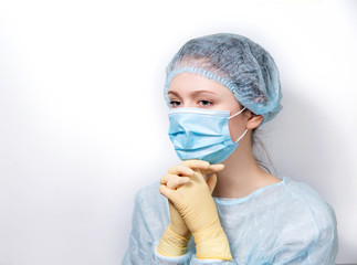 A young doctor in medical dress clasped her hands in prayer.