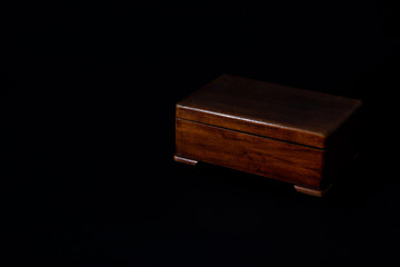 Old wooden casket isolated on black background. Wooden box for different decorations or small
trifles. Copy space. Top view. Flat layout. Minimal background.