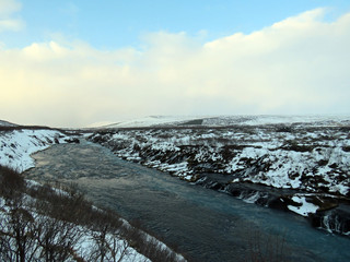 snowy landscape scene in Iceland with waterfall
