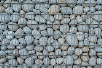 Gabion wall made of round rocks with steel wire net