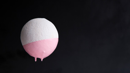 Oranges dripping paint isolated on a black background.