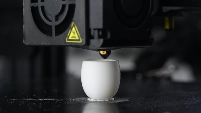 4K The 3D printer prints white plastic model of egg. modern technology.