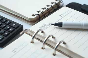  open diary, pen and calculator on table 