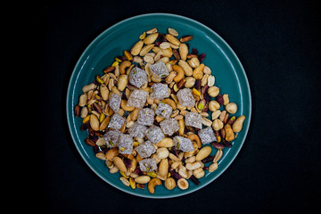 mixed nuts from above. Nuts of granite on a black background. Nuts shot from the top. nuts on a black background. peanut, cashew, roasted chickpea, hazelnut, pistachio, almond, roasted chickpea.