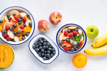 Fresh organic fruit salad with Chia seeds. Healthy breakfast set on grey background. The concept of delicious and healthy food. Top view, copy space