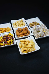 mixed nuts from above. Nuts of granite on a black background. Nuts shot from the top. nuts on a black background. peanut, cashew, roasted chickpea, hazelnut, pistachio, almond, roasted chickpea.