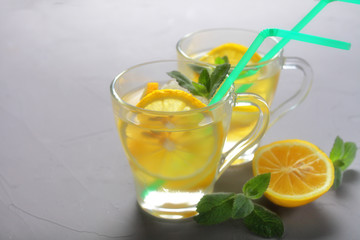 two glass mugs of lemonade on a gray background, place for your text, soft focus