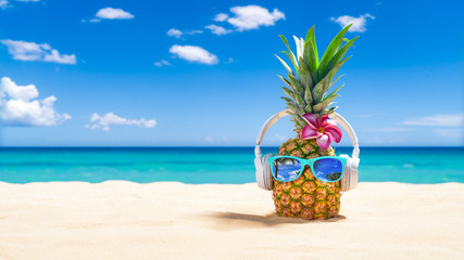 Pineapple with sunglasses and headphones at tropical beach - Holiday Vacation Concept - Powered by Adobe