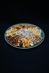 Obraz na płótnie Canvas mixed nuts from above. Nuts of granite on a black background. Nuts shot from the top. nuts on a black background. peanut, cashew, roasted chickpea, hazelnut, pistachio, almond, roasted chickpea.