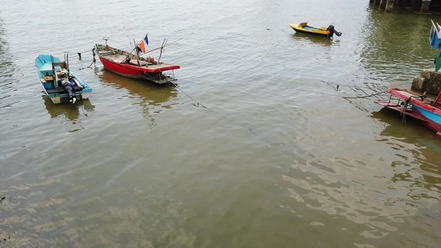 A small multi-colored fisherman boat floating on the sea Summer daytime