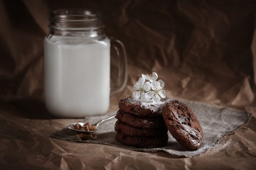 chocolate chip cookies with nuts and milk in a mug. calories homemade baking.