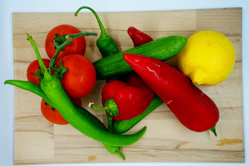 salad content top view. Fresh vegetables on wooden cutting board. salad ingredients. healthy foods. paprika, cucumber, green pepper, lemon, tomato for salad.