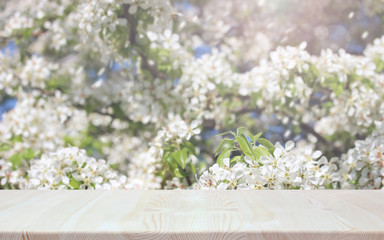 wooden table on a blurry background of a blooming garden.