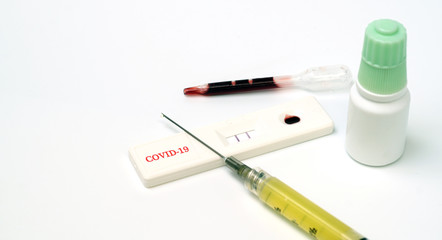 Rapid test kit for the coronary-19 virus, a vaccine contained in a syringe on a white background
