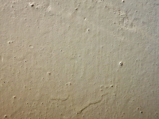 The current white paint on the wall. Brooks of liquid. Vertical flows.