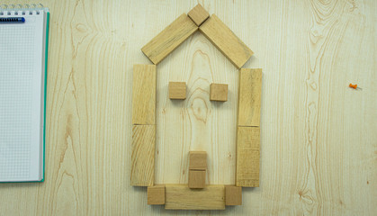 House concept made of wooden sticks on office table. To dream of buying a house.