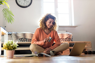 Smiling woman at home shopping online
