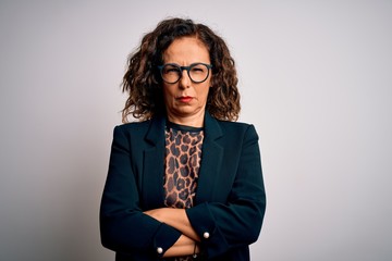 Middle age brunette business woman wearing glasses standing over isolated white background skeptic...