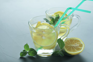 two glass cups of lemonade on a gray background, toned blue color, place for your text