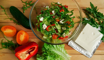 Salad with arugula, tomato, cucumber, fetax cheese and bell pepper.