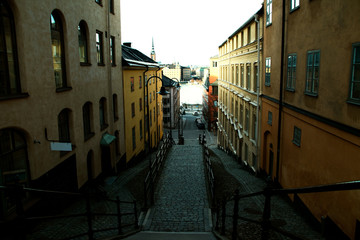Fototapeta na wymiar Picturesque cobblestone pathway for pedestrians down the stairs towards the water between old buildings in Stockholm, Sweden