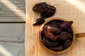 Dried dates fruit in bowl on wooden table. Top view