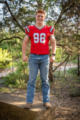 Fototapeta premium Young, attractive boy with red hair taking graduation pictures