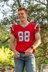 Fototapeta premium Young, attractive boy with red hair taking graduation pictures