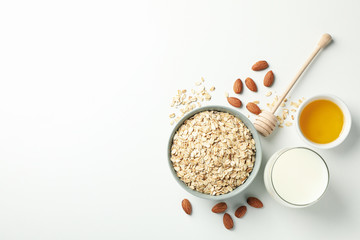 Composition with oatmeal flakes on white background, top view. Cooking breakfast