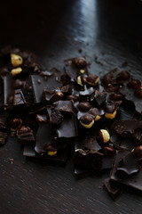 Dark chocolate with nuts on the dark wooden background