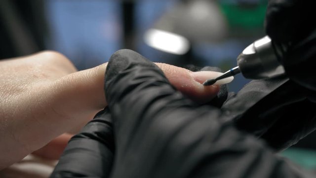 beautician making hardware manicure. woman hands receiving nail procedure in beauty salon