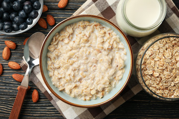 Composition with oatmeal porridge on wooden background. Cooking breakfast