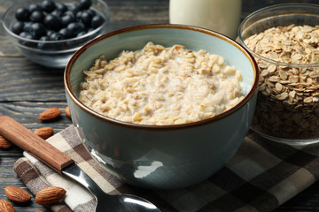 Composition with oatmeal porridge on wooden background. Cooking breakfast