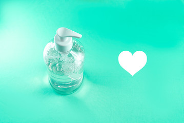 Container with alcohol gel on the light blue background