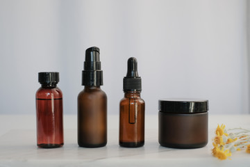 set of amber glass cosmetic skincare packaging . blank and no label with flower.