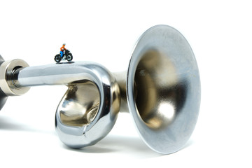 A motorcyclist rides along a metal horn - Tiny People Travelling