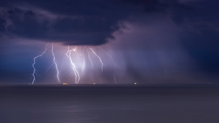 Naklejka na ściany i meble beautiful lightning in the sea, thunderclouds with lightning, lightning discharges