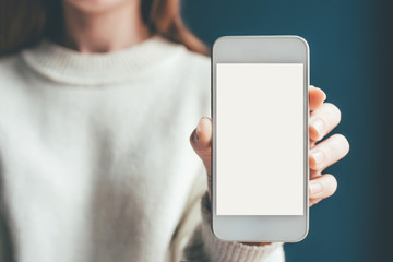 Woman's hand holding phone with white screen. Copy space for your text message.