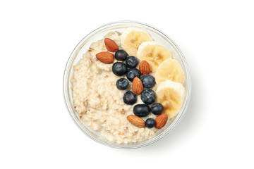 Bowl with oatmeal porridge and ingredients isolated on white background